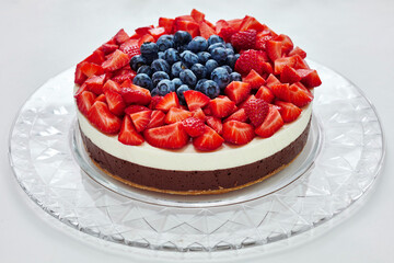 Strawberry-grape cheesecake on white background