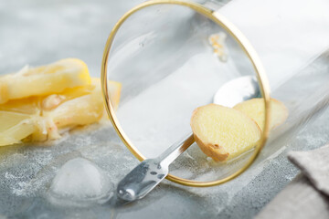 Refreshing ginger in a glass with drop water on a marble grey table.