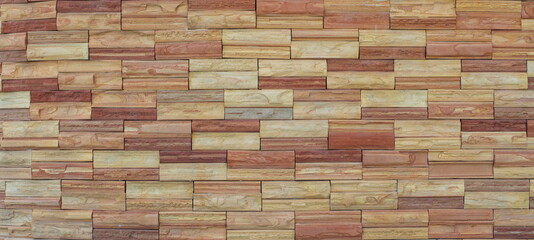 Close-up full-frame shot of brick wall background and texture. Interior and exterior modern house decoration. Cementing of materials with concrete for home. Golden sandstone.