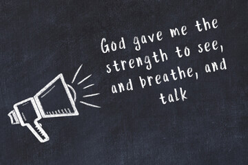 Chalk loudspeaker and wise quote on black desk