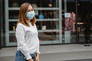 young woman with shopping bags and  protect face mask. Women with face mask travel in the city new life in the city