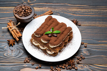 Classic tiramisu dessert on ceramic plate on wooden background