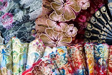 Flamenco hand fans with colorful floral pattern bunched together for abstract background. Spanish or Chinese influence