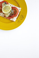 Salty crackers with sardine, tomato and lemon from above