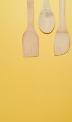Variety of spatulas on spacious yellow surface.