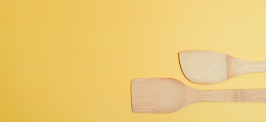 Two spatulas on yellow, horizontal.