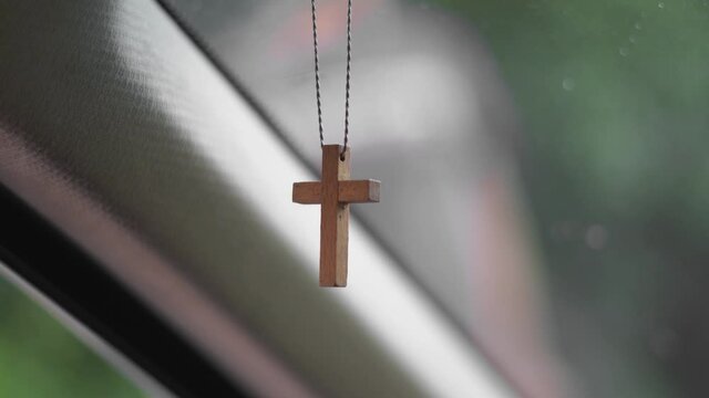 Religious cross symbol of Christian God in car interior. Safe ride wish