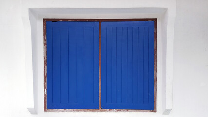 deep blue classic window on clean white wall house