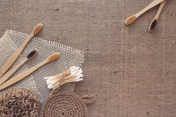 Frame made of natural bathroom and home spa tools, sustainable zero waste and lifestyle concept. Wooden toothbrushes, bamboo swabs, soap, dry shampoo, toothpowder on fabric background with copy space