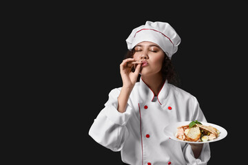 Female African-American chef with tasty dish on dark background