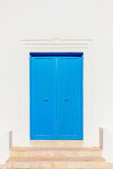 Naklejka na ściany i meble Old blue door on a white wall