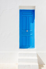 Old blue door on a white wall