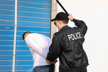 Aggressive police officer mistreating man outdoors