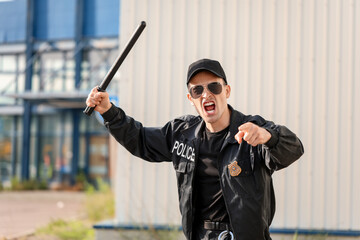 Aggressive police officer with baton outdoors