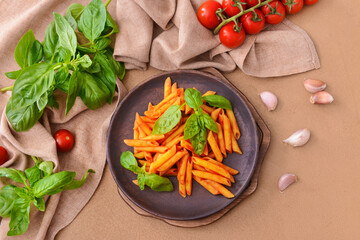 Plate with tasty pasta, basil and tomato sauce on color background