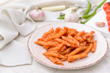 Plate with tasty pasta and tomato sauce on table