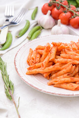 Plate with tasty pasta and tomato sauce on table