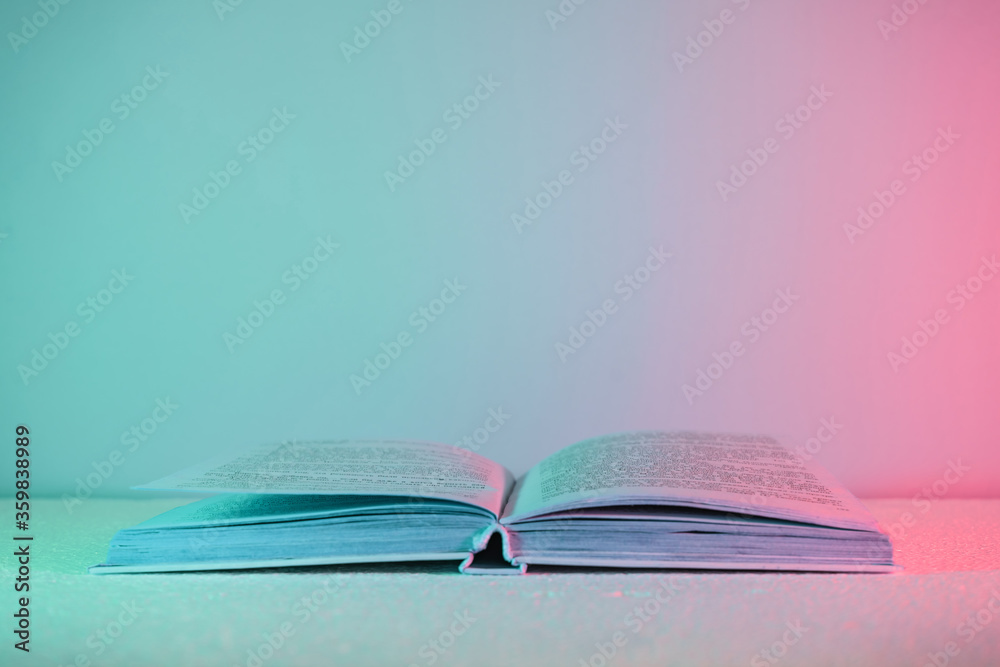 Poster beautiful open old book pages in neon light. minimalism retro style concept. 80s. background pattern