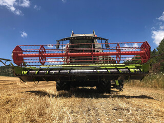 Combine harvester parked in a large Wheat field.