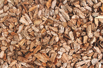 Full frame background made of natural untreated tree bark pieces - wood chip mulch for gardening or natural themes. Copyspace for you text or presentation, brown wooden texture, biofuel concept