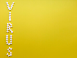 word virus made of pills on yellow background