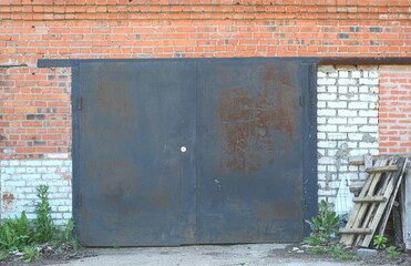 A large metal door in the wall of their red and white bricks