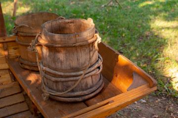 brown wooden bucket and an old traditional reservoir stands against the backdrop of the earth