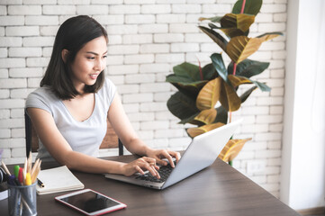 Beautiful young woman works online for the job conference with friend colleague at cozy living room...