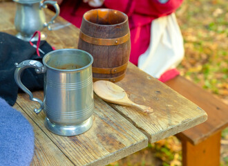 silver and ceramic tin mug on a wooden table picnic dinner tableware medieval pub