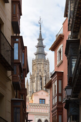 Fototapeta na wymiar One of the towers of the cathedral of Toledo is visible among the modern facades of its streets