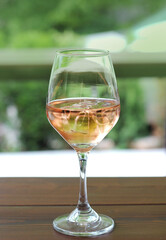 A glass of rose wine on the table, close up