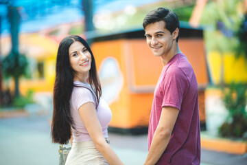 young couple dating and having fun at amusement park, concept of happy, love, and relaxing