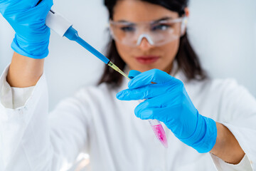 Student in White Coat, Working in Research Laboratory Using Micro Pipette and Test Tube