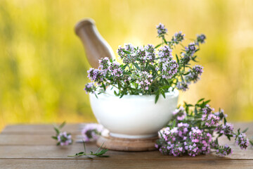 bunch of fresh thyme on a wooden table against the background of nature. Copy space