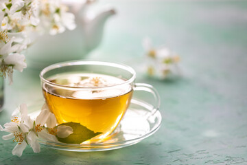 Jasmine flower tea on green stone, spa concept. Copy space