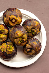 mangosteen round fruit with tough bark and white core distributed in asia vietnam