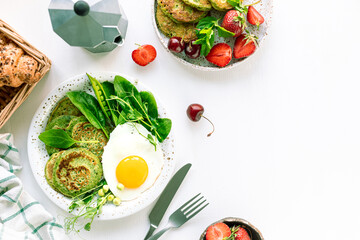 Tasty healthy breakfast. Green pancakes with spinach, egg and young green peas. top view. copy space.