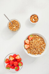 Homemade granola in a bowl with fresh strawberries, nuts and yogurt. Healthy and delicious Breakfast. The concept of summer food. Top view, selective focus.