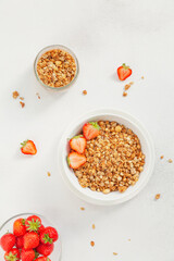 Homemade granola in a bowl with fresh strawberries, nuts and yogurt. Healthy and delicious Breakfast. The concept of summer food. Top view, selective focus.