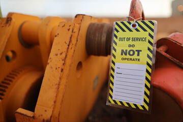 Safety workplaces yellow out of service tag attached on faulty damage defect of heavy duty lifting...