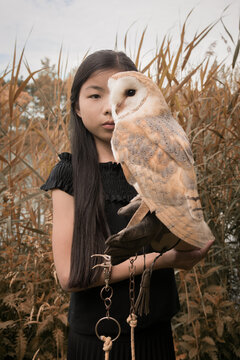 Portrait of girl holding barn owl