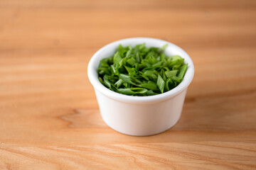 Bowl with tasty fresh arugula on grey table