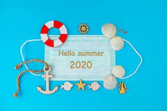Summer composition in marine style, with shells and wooden figures on a blue background. Concept of summer vacation at the sea. flat lay, copy space. text " Hello summer 2020"