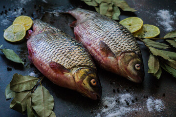 Two river crucians prepared for frying on a wooden table.