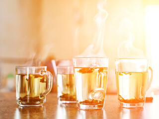 Cup of tea with steam at sunrise