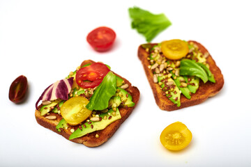 Toasts with vegetables, avocado, tomatoes, a set of seeds on a white background. Healthy food, diet concept.