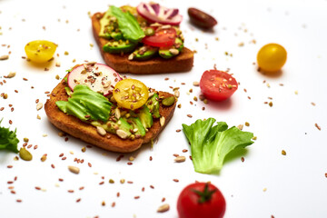 Toasts with vegetables, avocado, tomatoes, a set of seeds on a white background. Healthy food, diet concept.