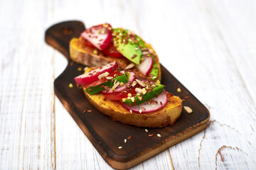 Toasts with vegetables, avocado, tomatoes, a set of seeds on a white background. Healthy food, diet concept.