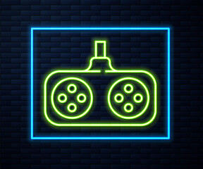 Glowing neon line Gamepad icon isolated on brick wall background. Game controller. Vector Illustration.