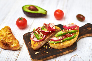 Toasts with vegetables, avocado, tomatoes, a set of seeds on a white background. Healthy food, diet concept.